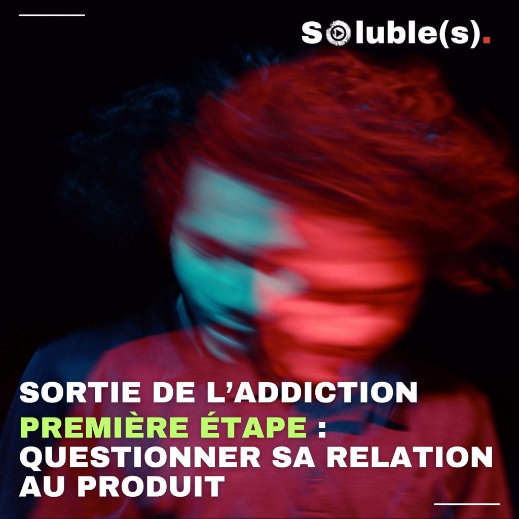 Image expressive pour illustrer la première étape de la sortie de l’addiction. On voit une personne floue et en mouvement, l’éclairage rouge et bleu accentue la sensation de trouble ou de questionnement intérieur. Texte en surimpression : « Sortie de l’addiction. Première étape : questionner sa relation au produit ». Visuel marquant, évoquant le processus de réflexion et le début du parcours de changement.